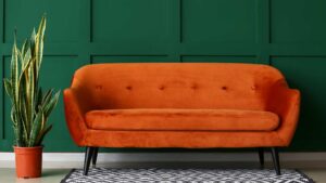 Canapé orange sur un mur vert foncé