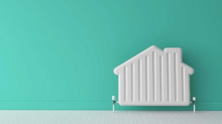 Radiateur/chauffage en forme de maison sur un mur vert